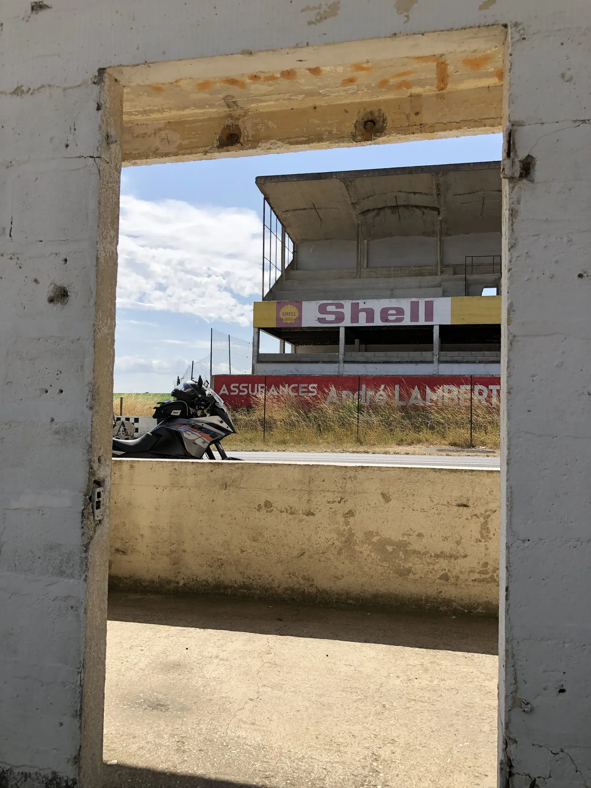 Abandoned Shell station viewed through concrete doorway, Gueux