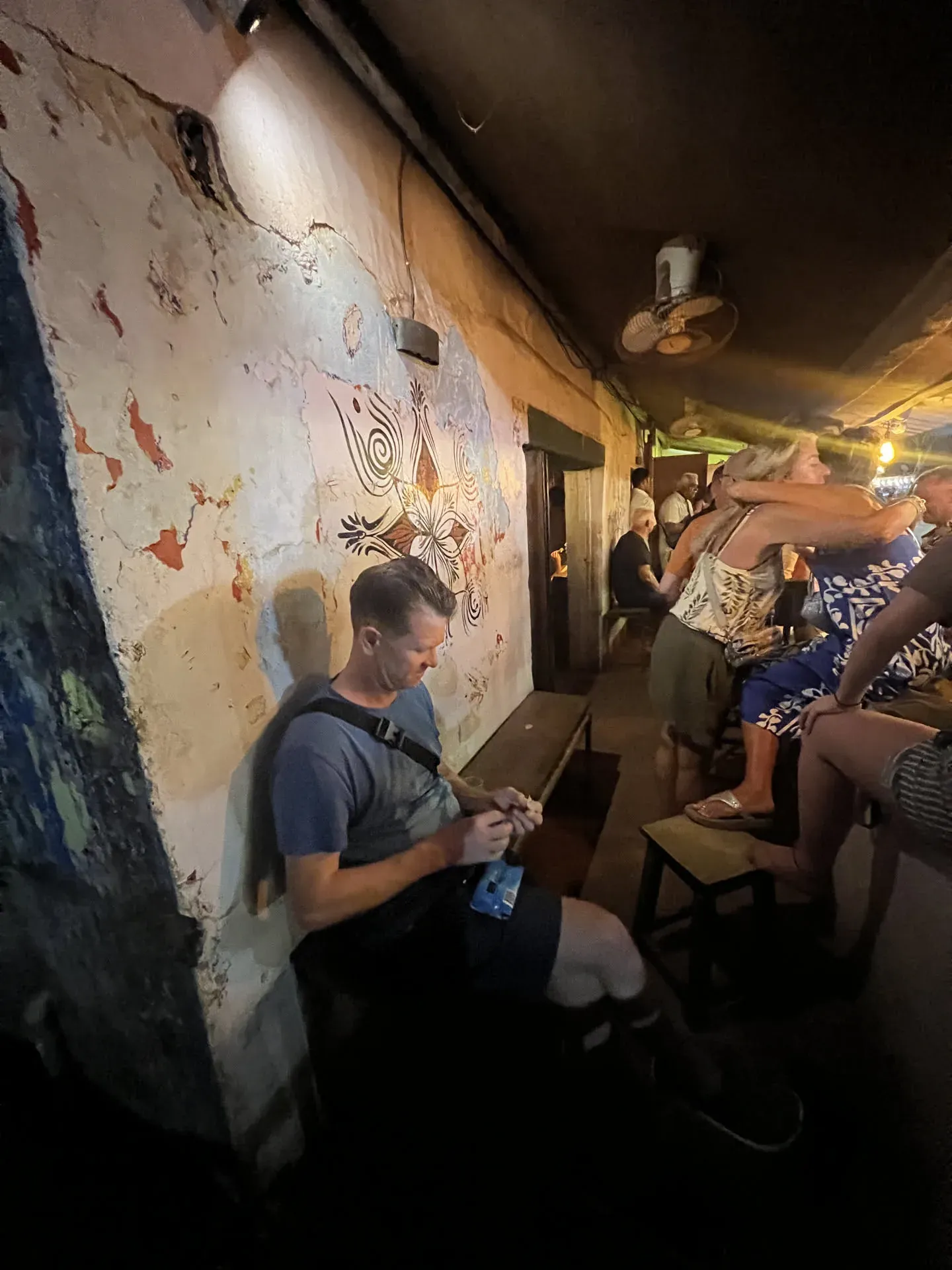 Man with drink at crowded bar, Agonda