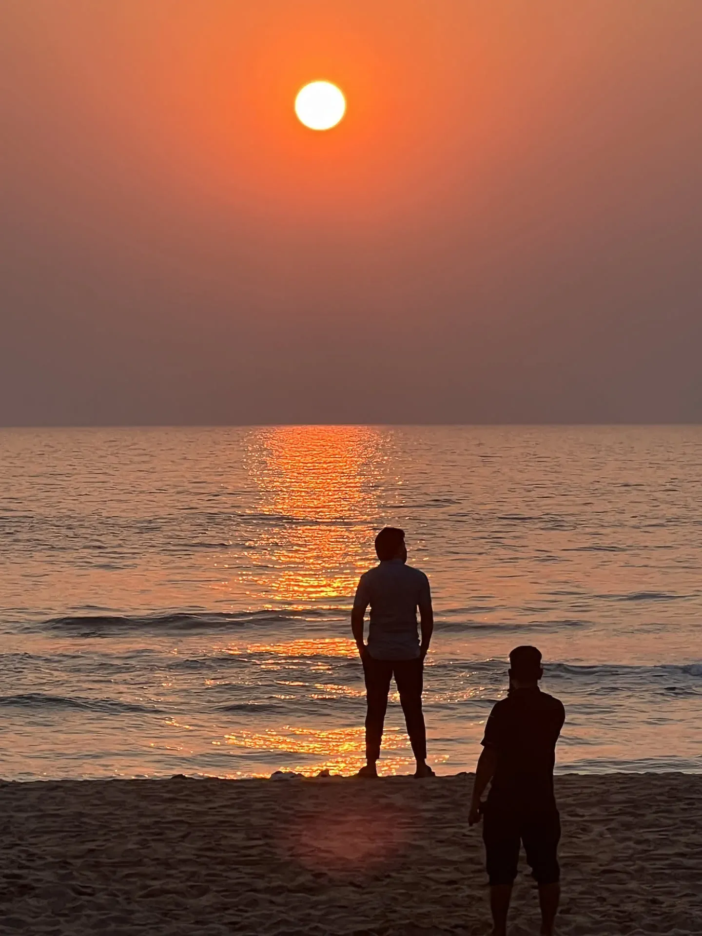 Two people watching sunset at Agonda beach