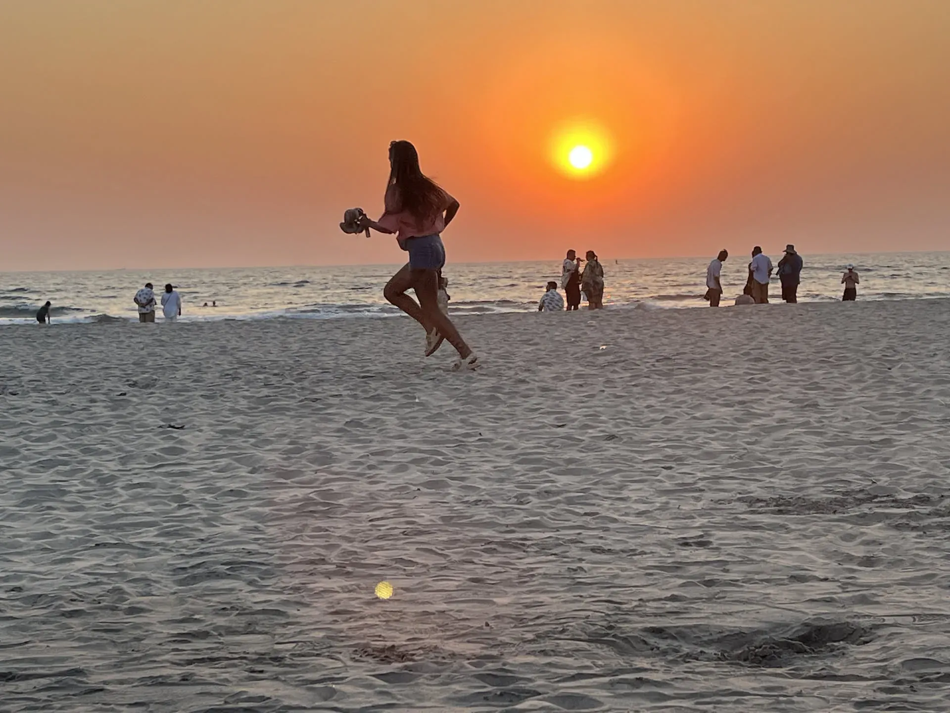 Woman jumping on beach at sunset, Morjim