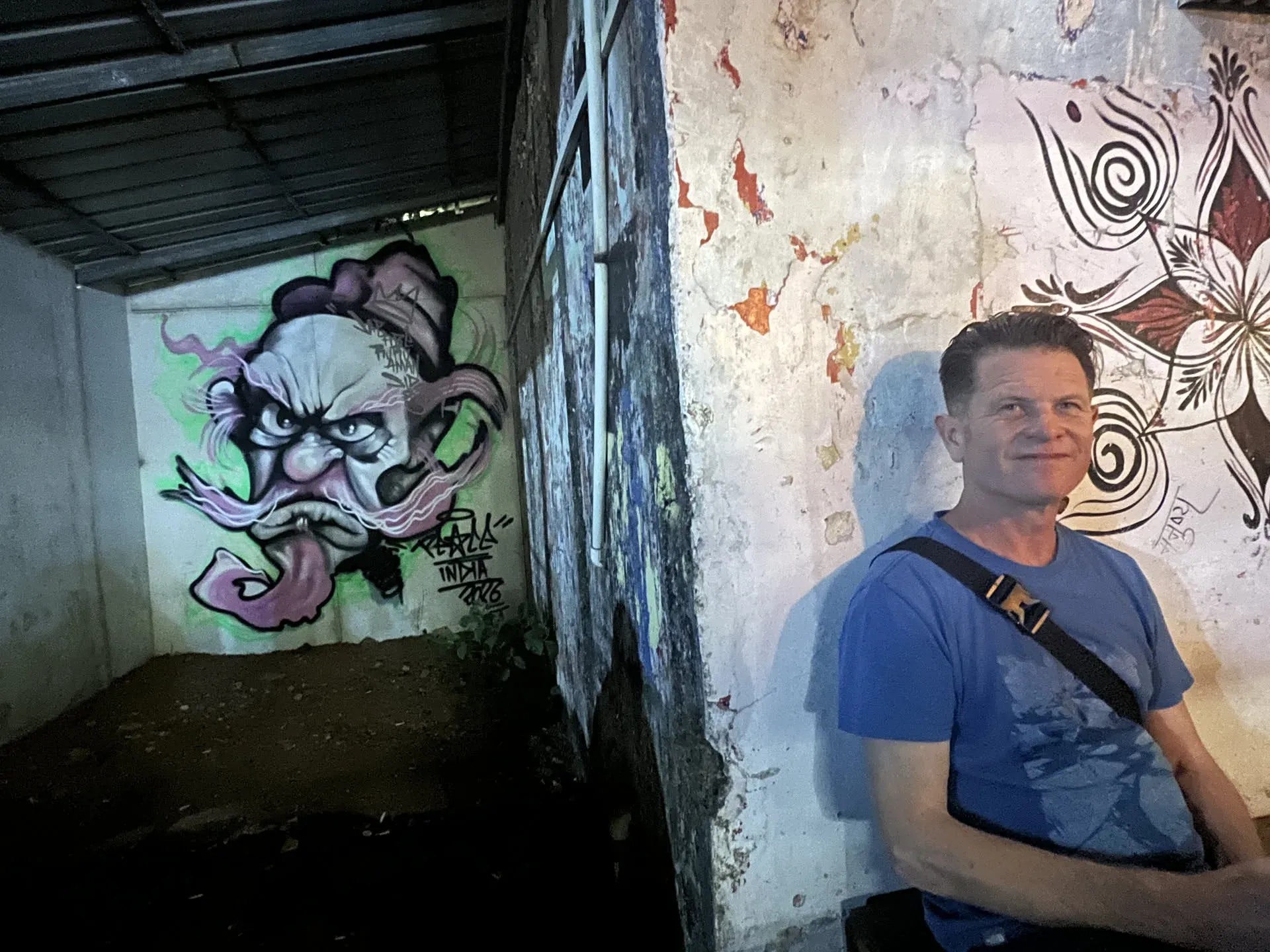 Man posing with street art in Agonda