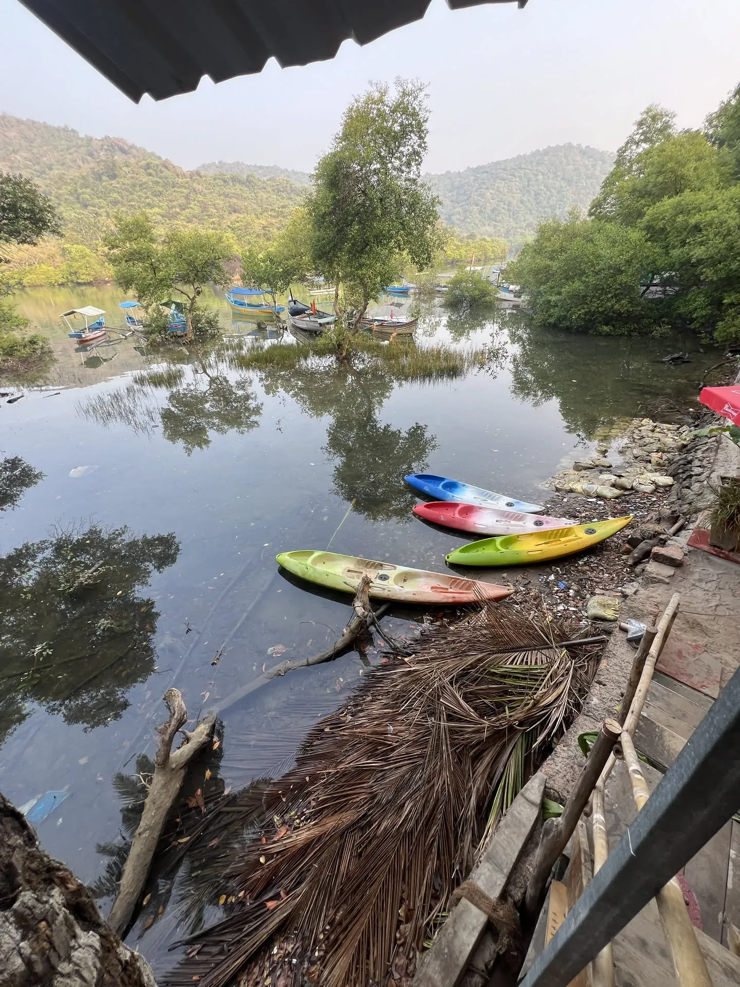 Colorful kayaks lined up at Devabag riverbank