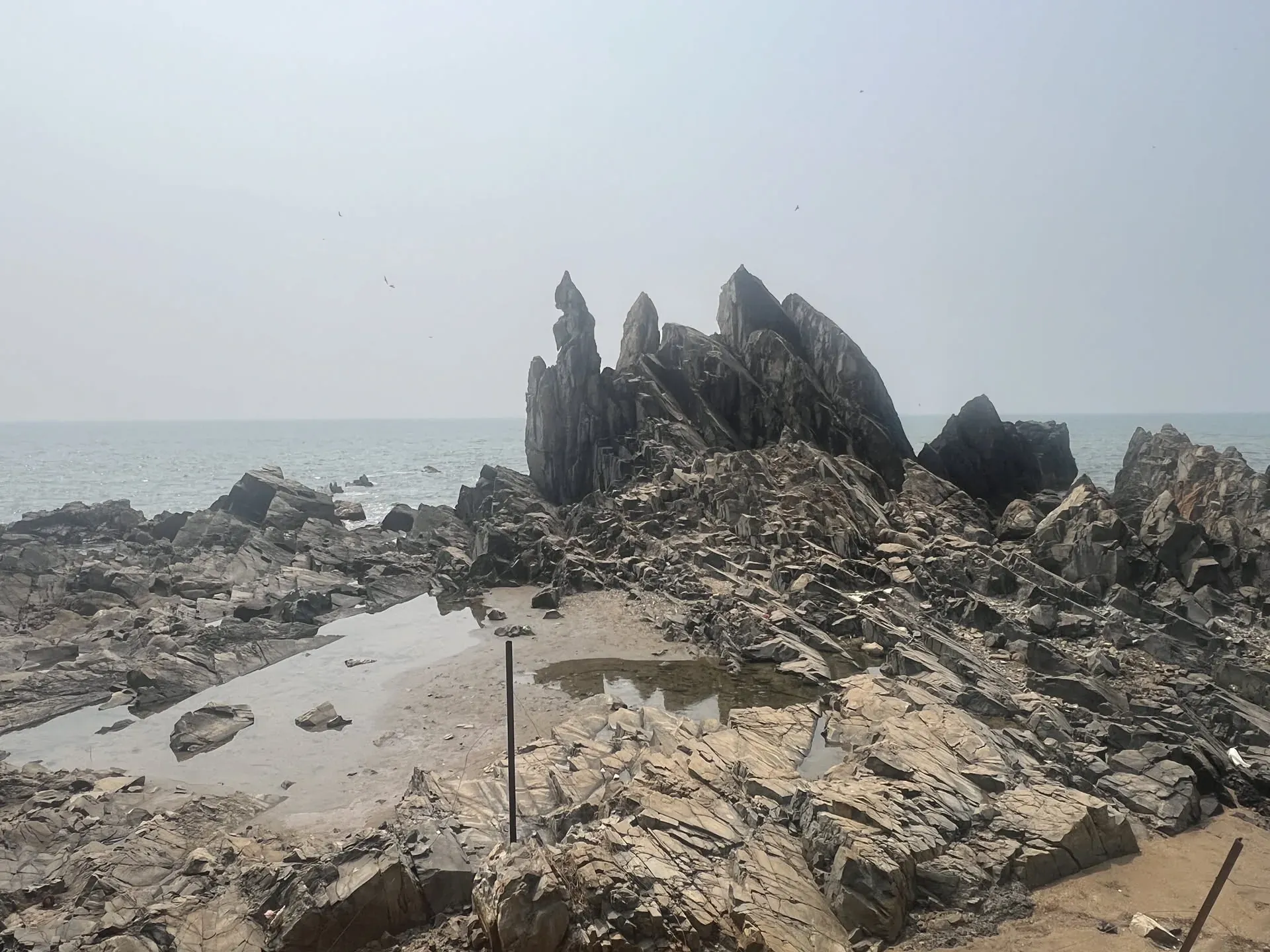 Dramatic rock formations and tidal pools at Querim beach