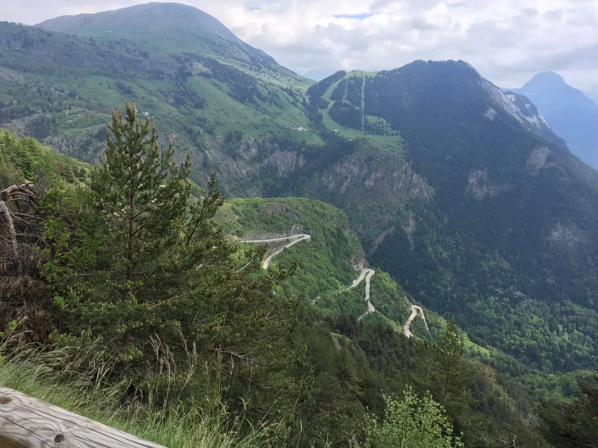 Winding mountain road through forested valleys, Huez