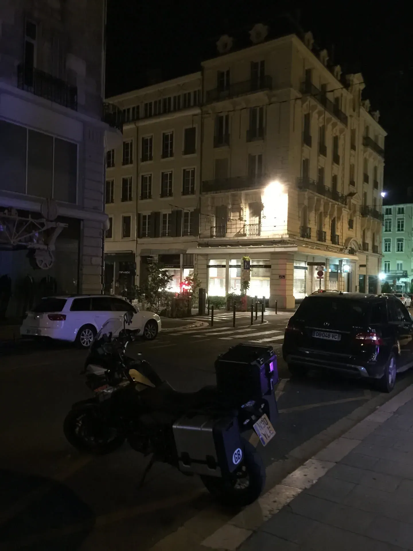 Night street in Grenoble with parked motorcycles and cars