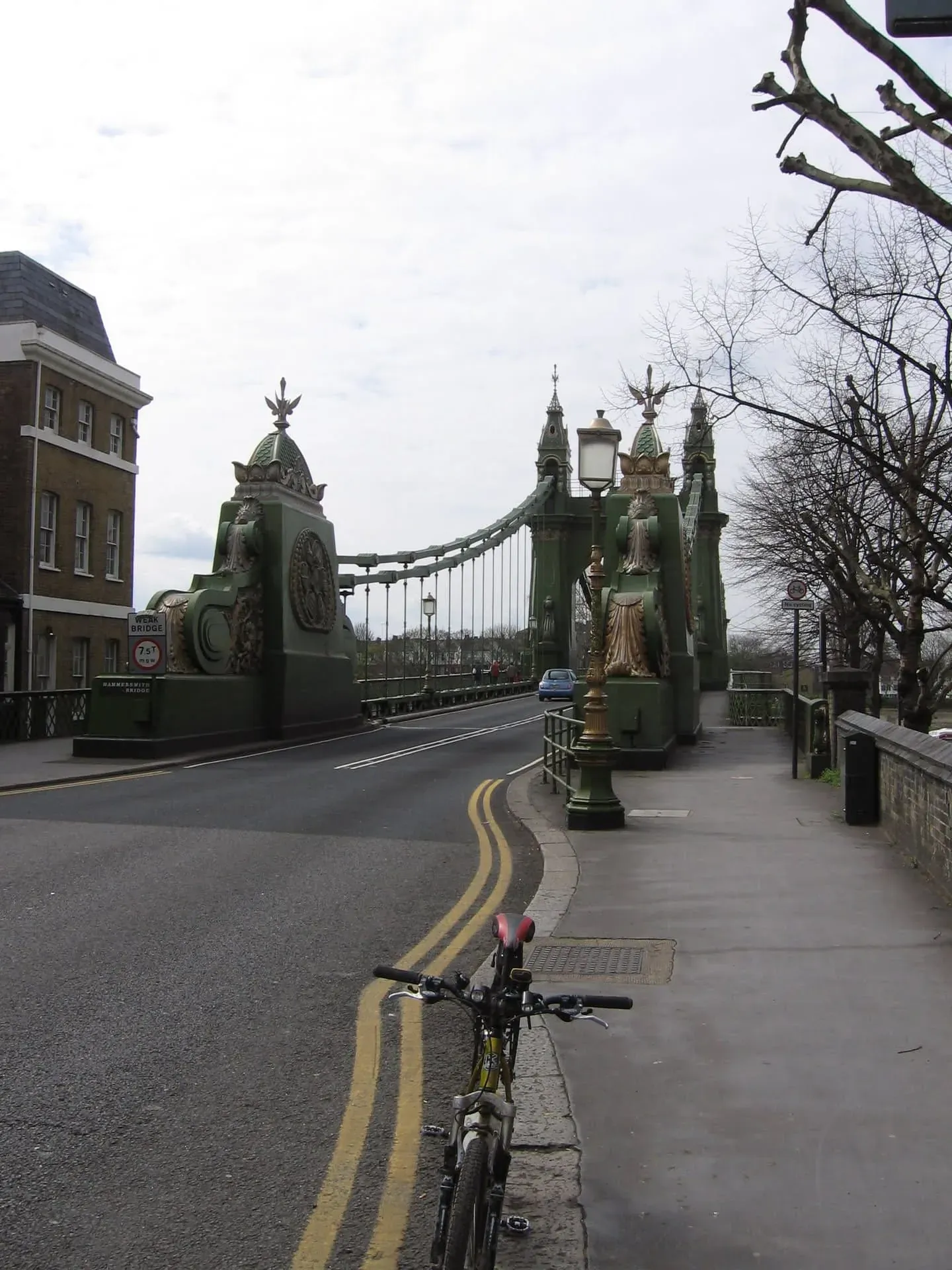 Ornate green bridge with golden statues spanning across road in London