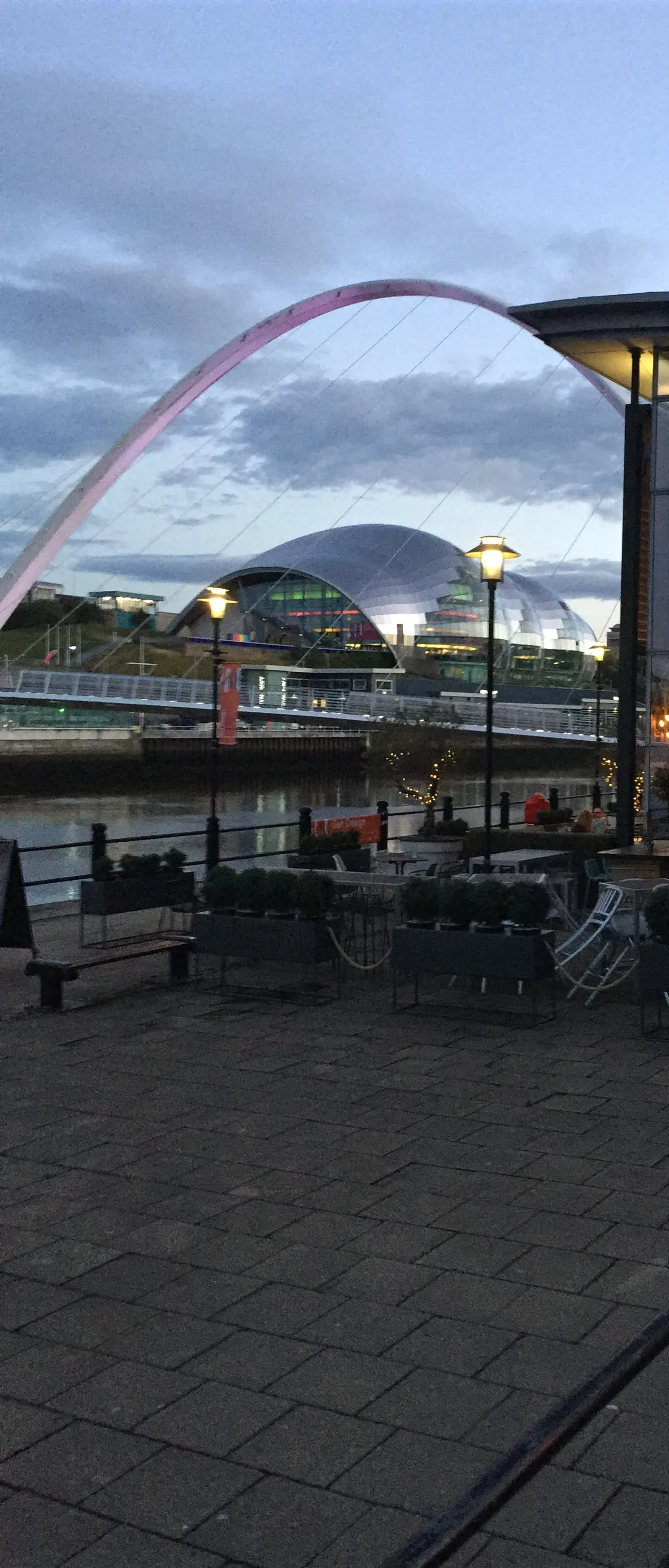 Pink arch bridge over river at dusk, Gateshead