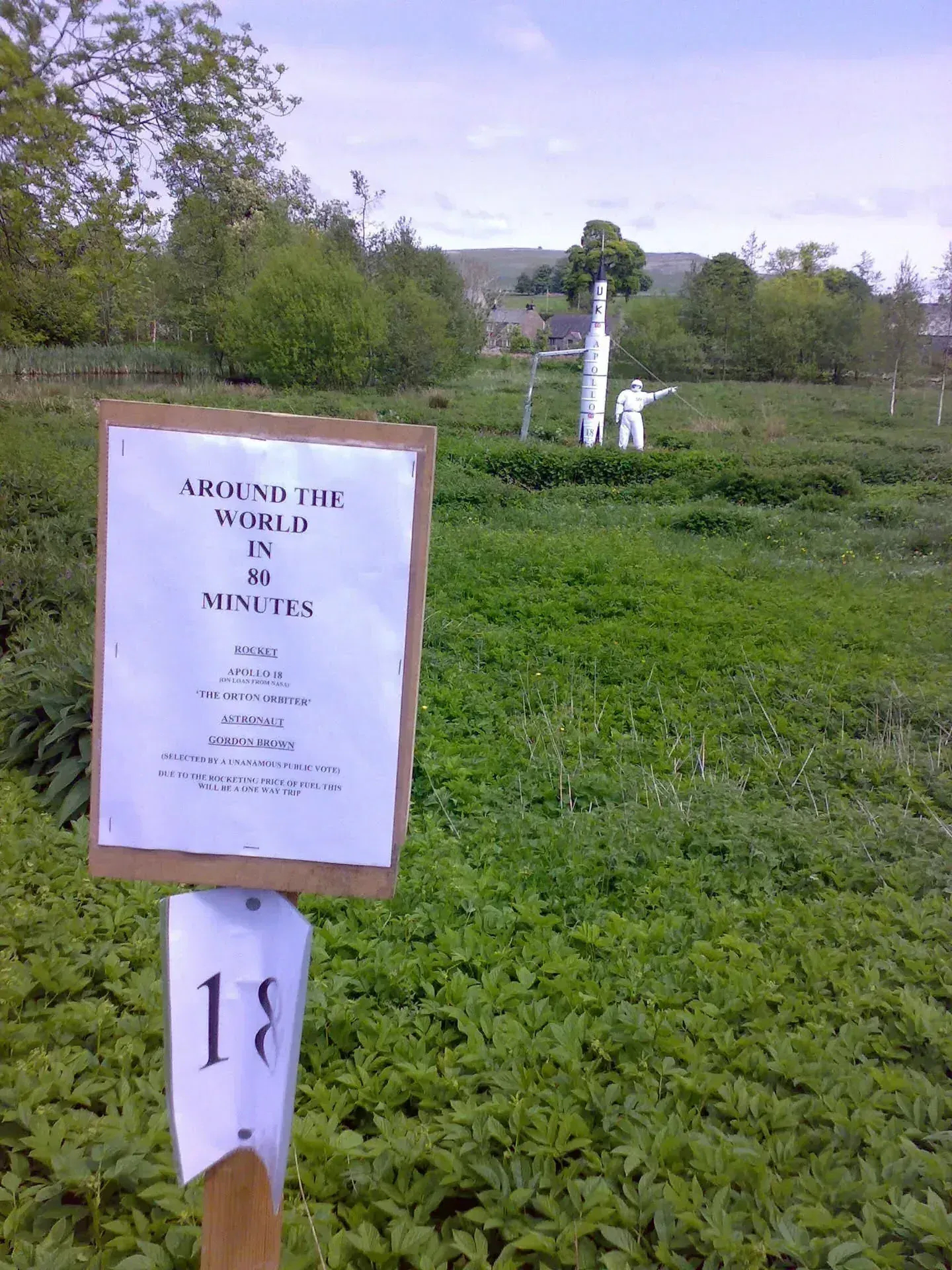 Upside-down photo of moss-covered ground with "Bournemouth 80 Whitehorse 11" directional sign