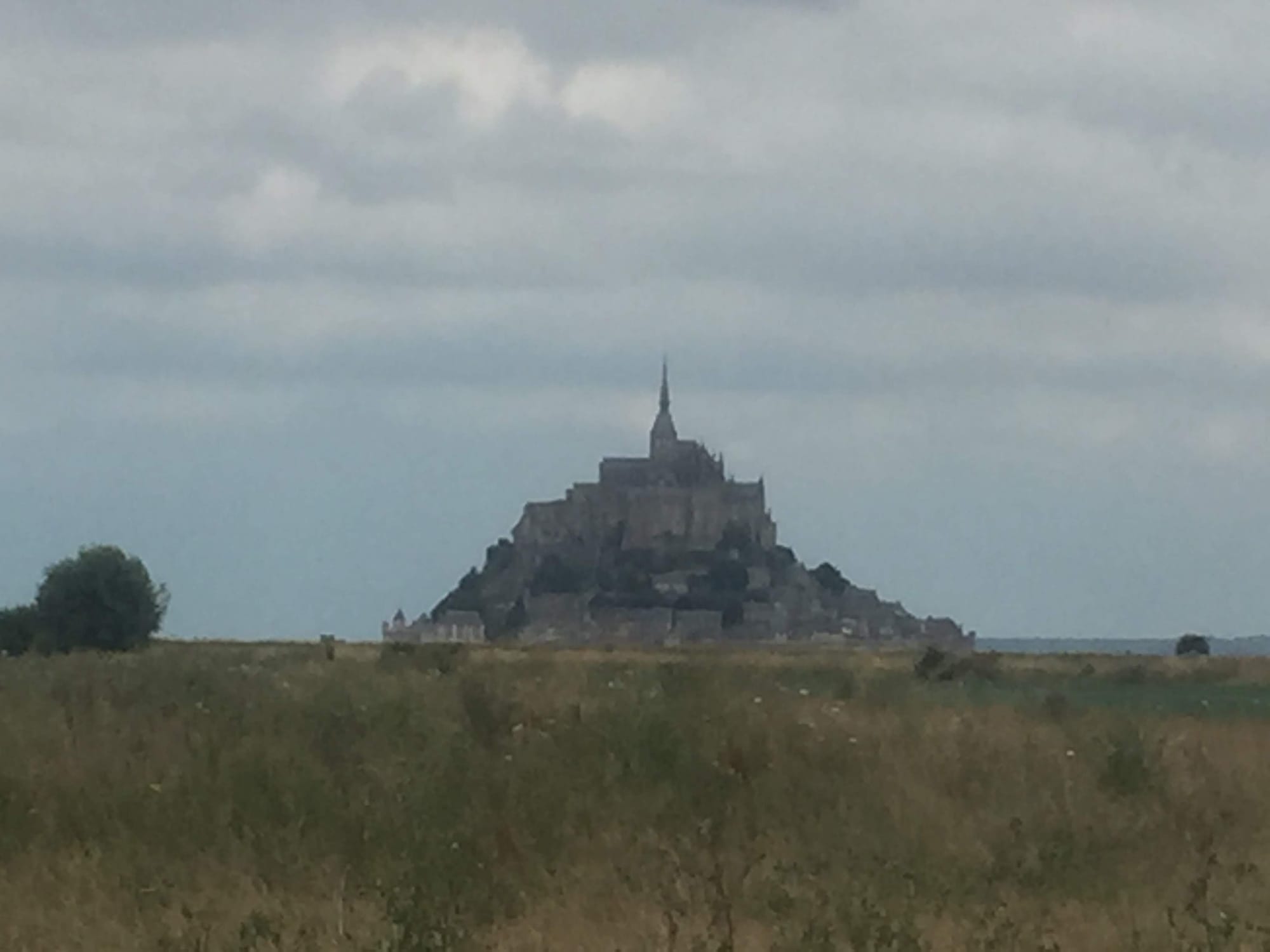 Mont-Saint-Michel castle rising from fields near Ardevon