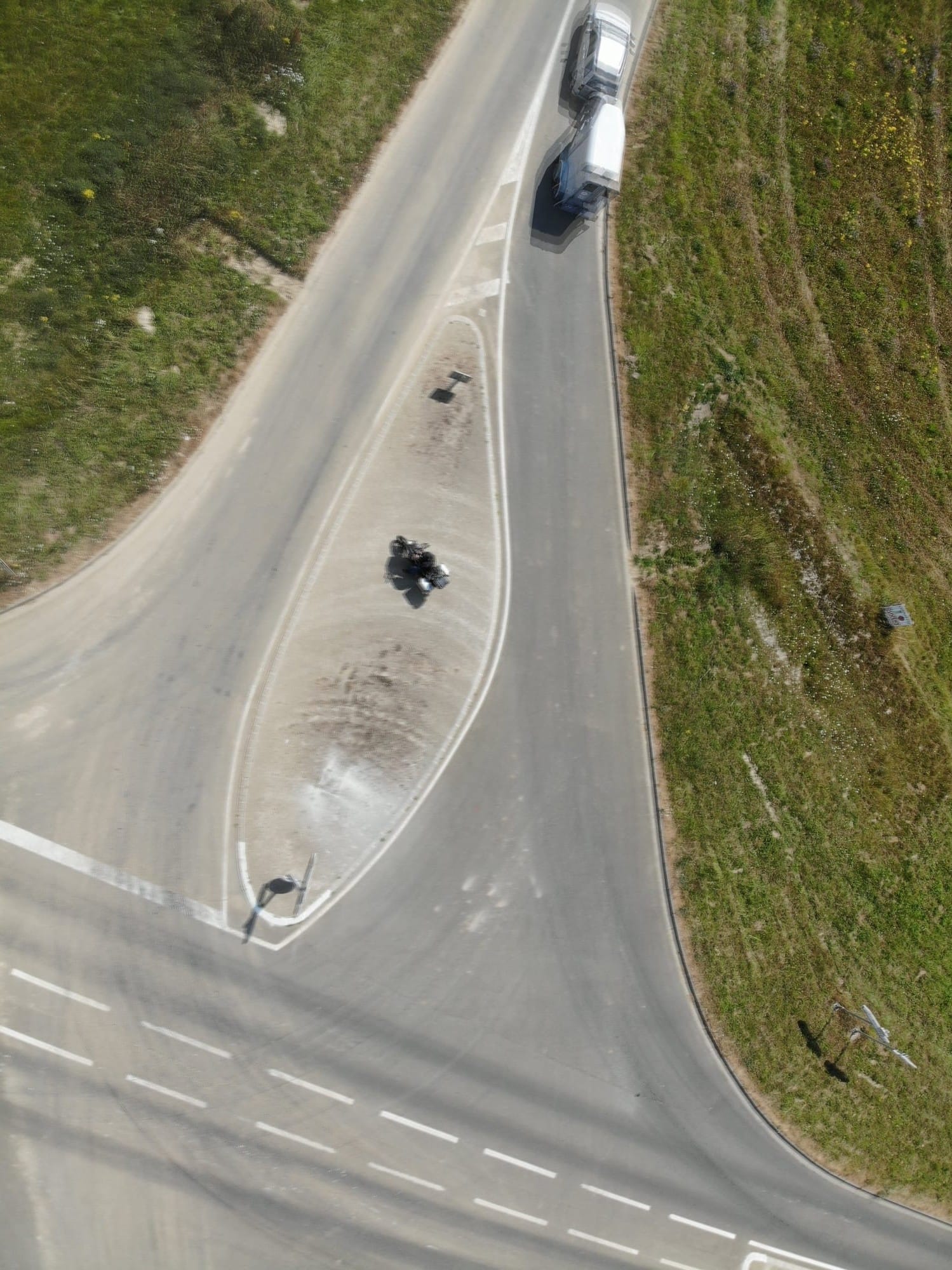 Aerial view of winding road with car and vegetation