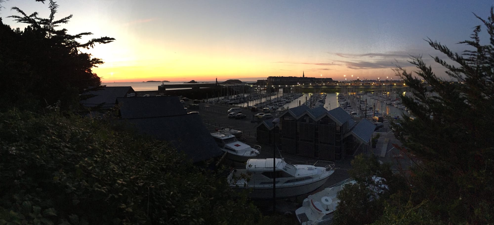 Sunset over harbor at Saint-Servan, boats moored below
