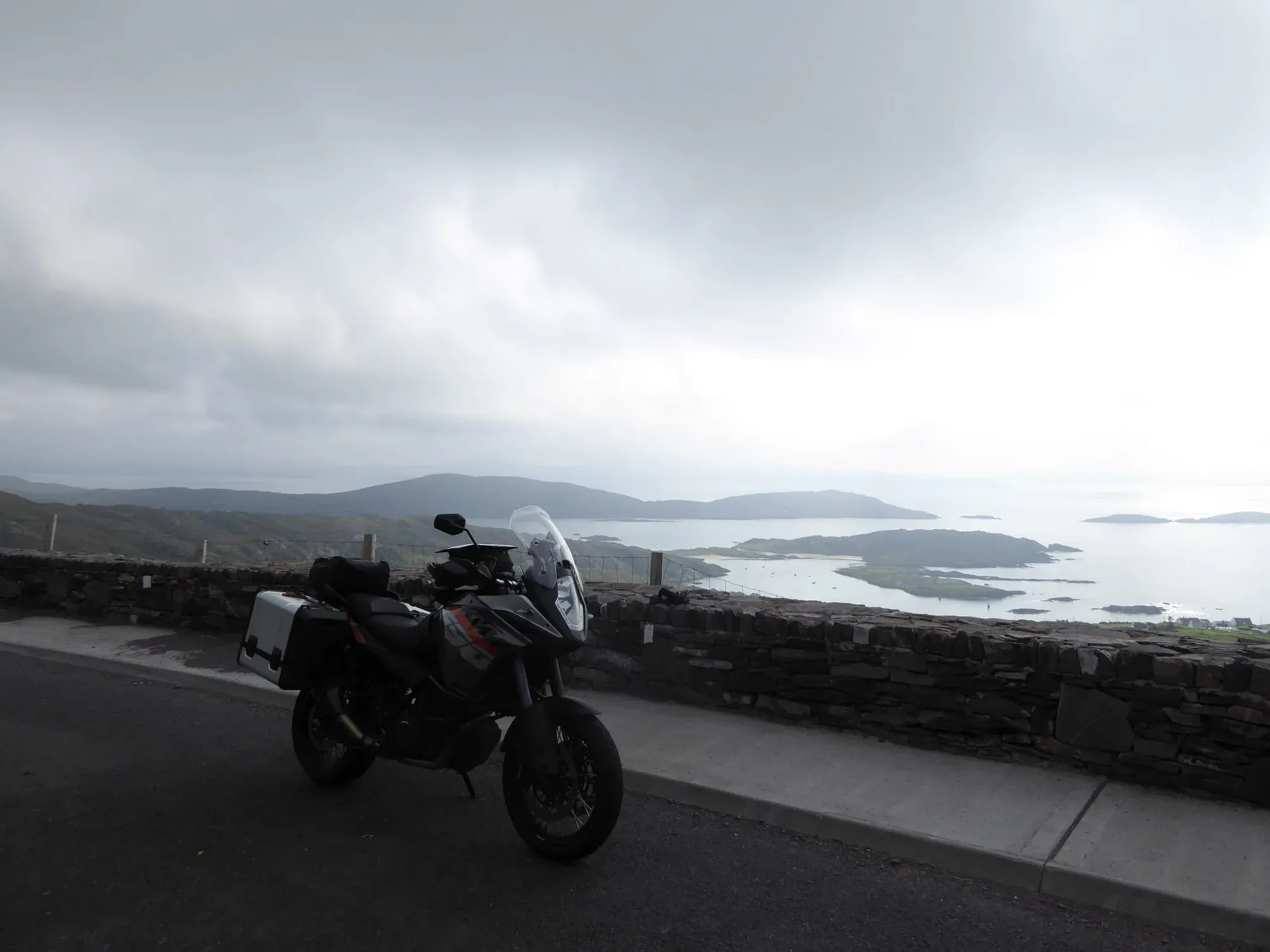 Black and orange adventure bike overlooking coastal islands and bay