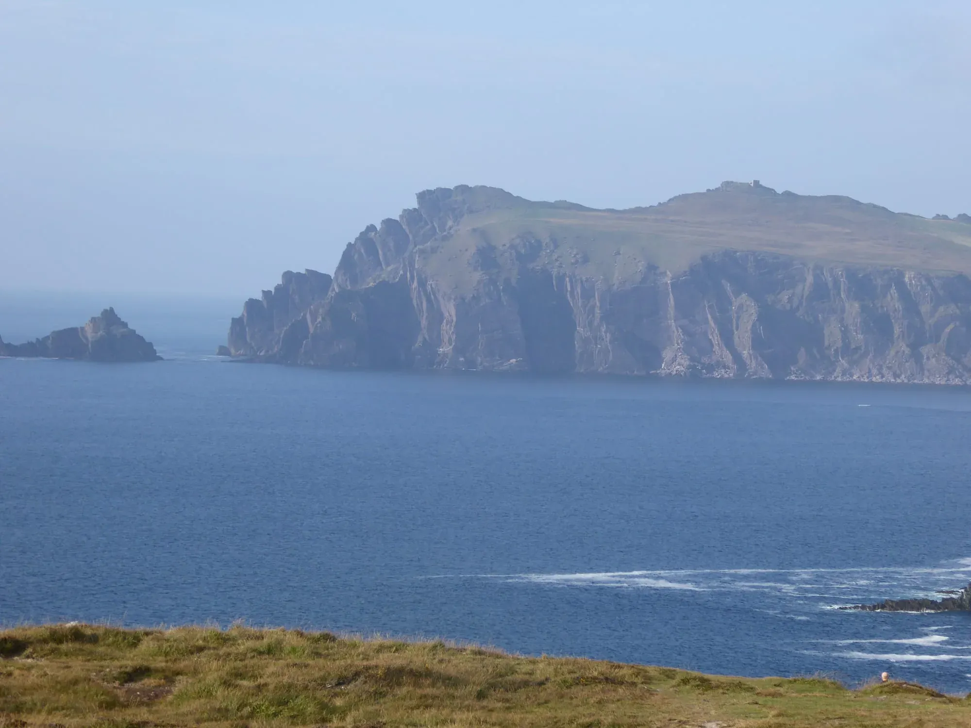 Dramatic basalt sea cliffs rising from blue ocean water