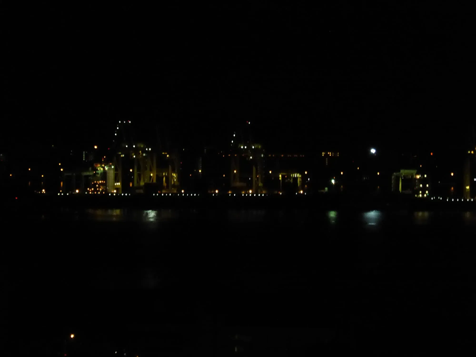 Nighttime cityscape with illuminated buildings reflected in water