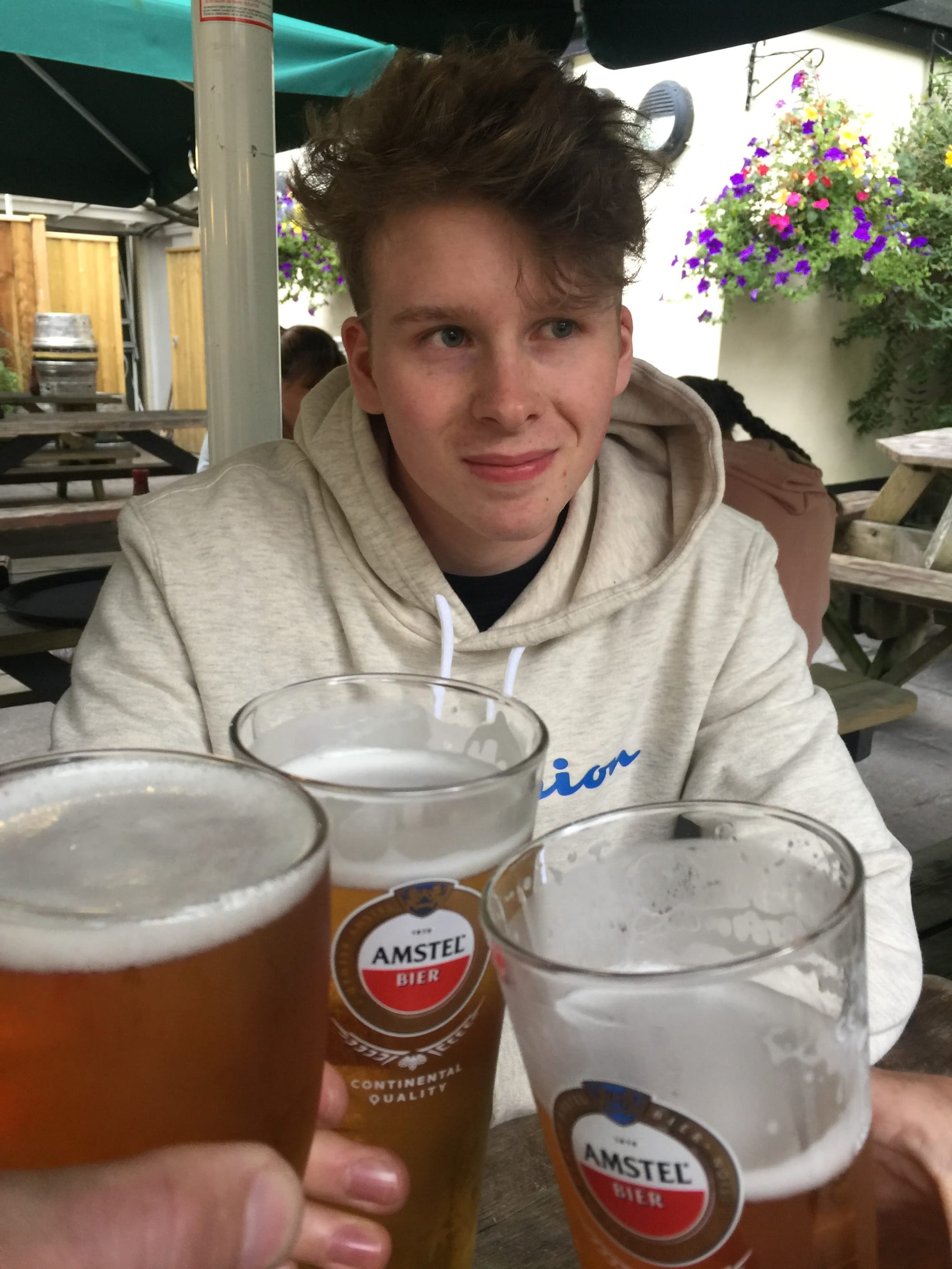 Teenager with Amstel beers at Padstow waterfront cafe