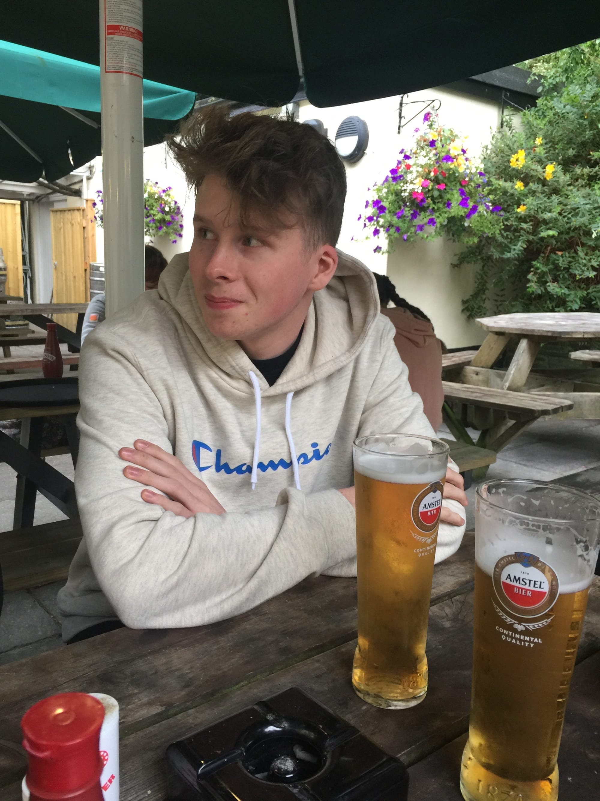 Young man with beer at Padstow waterfront table