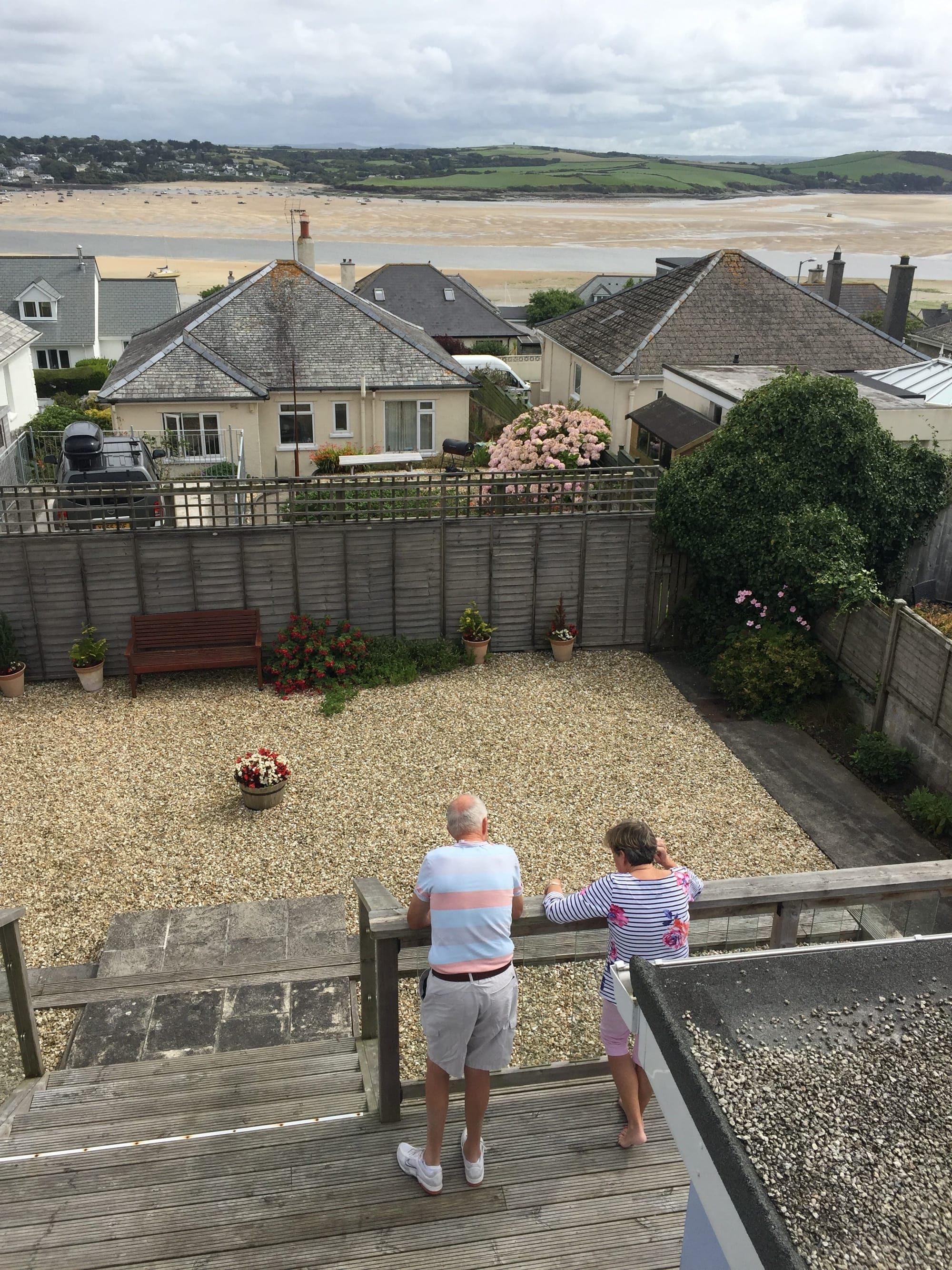 Two people viewing Padstow beach from seaside garden