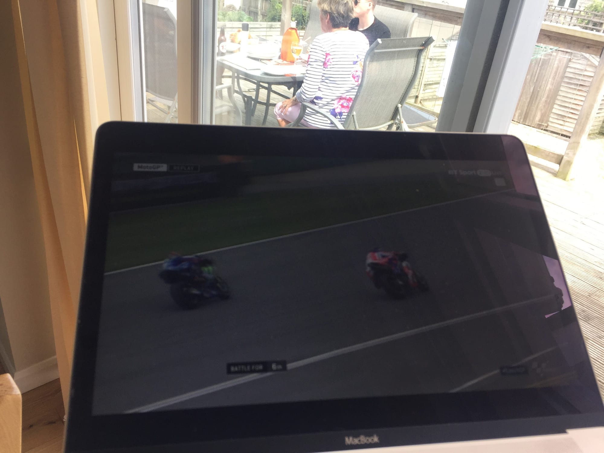 Racing game on MacBook, Padstow terrace visible behind