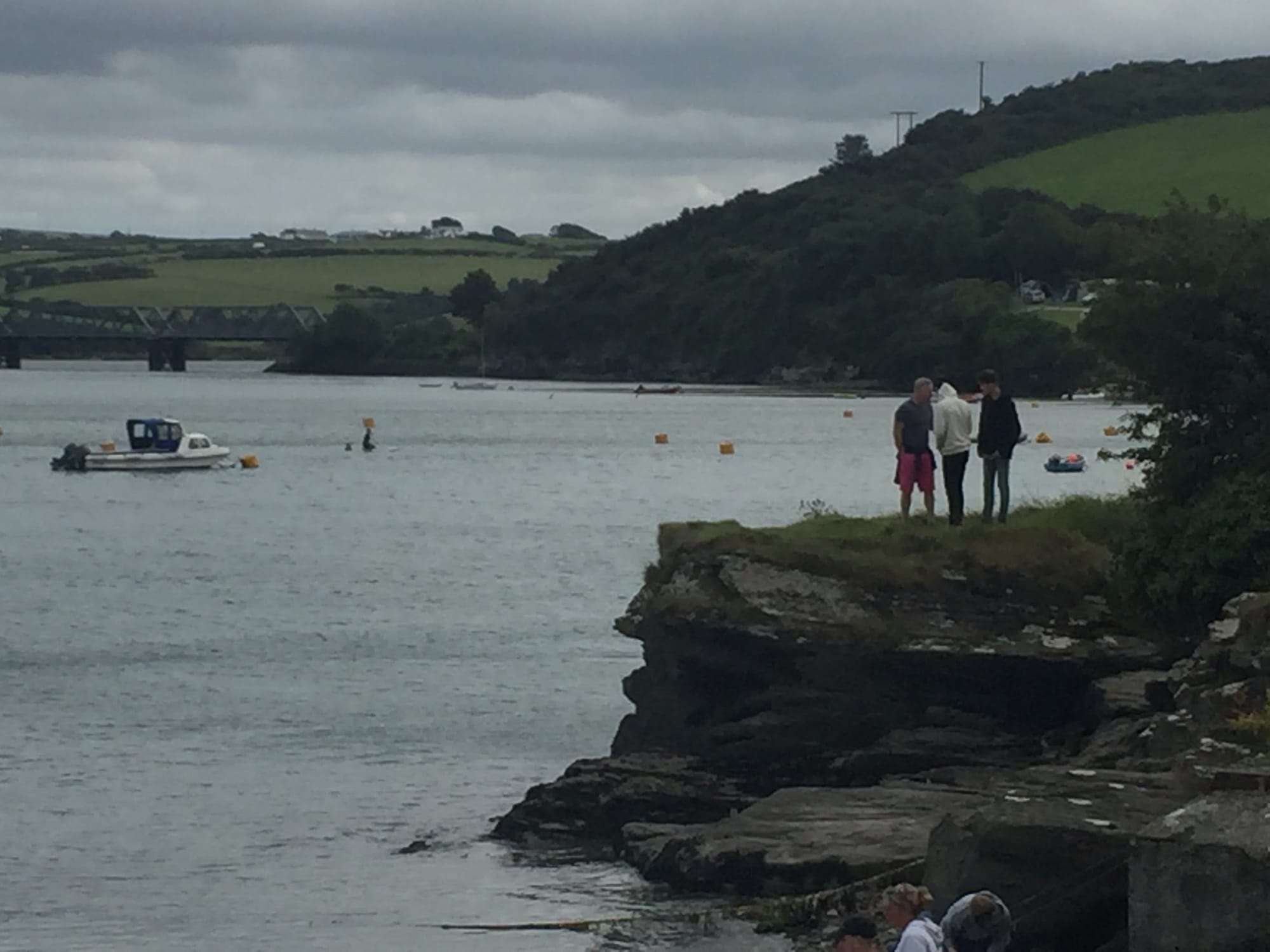 People standing on rocky shore at Padstow