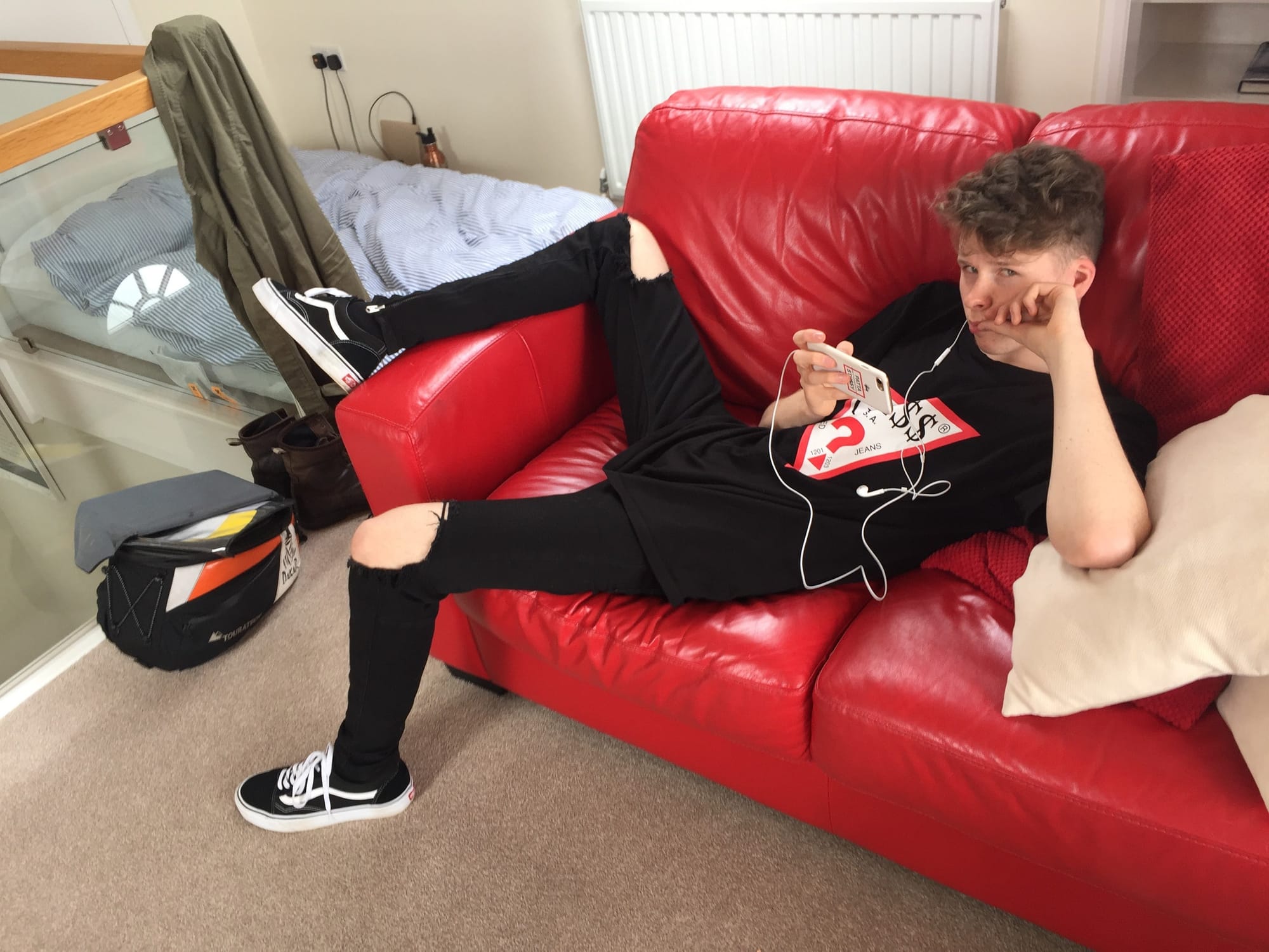 Teen relaxing on red sofa, Padstow