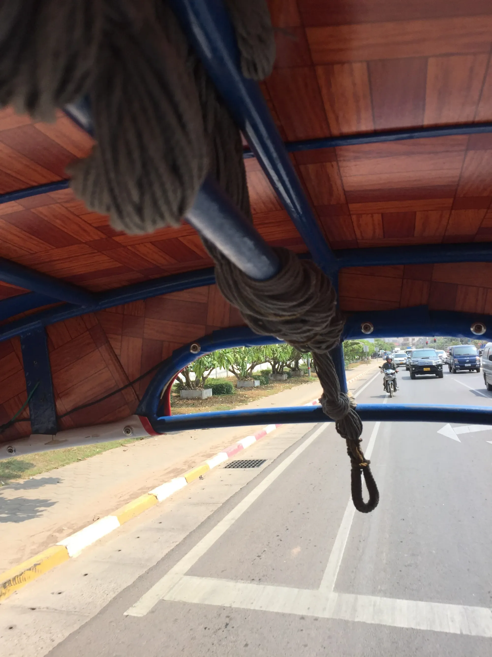 Kite with rope, road and parked cars visible below