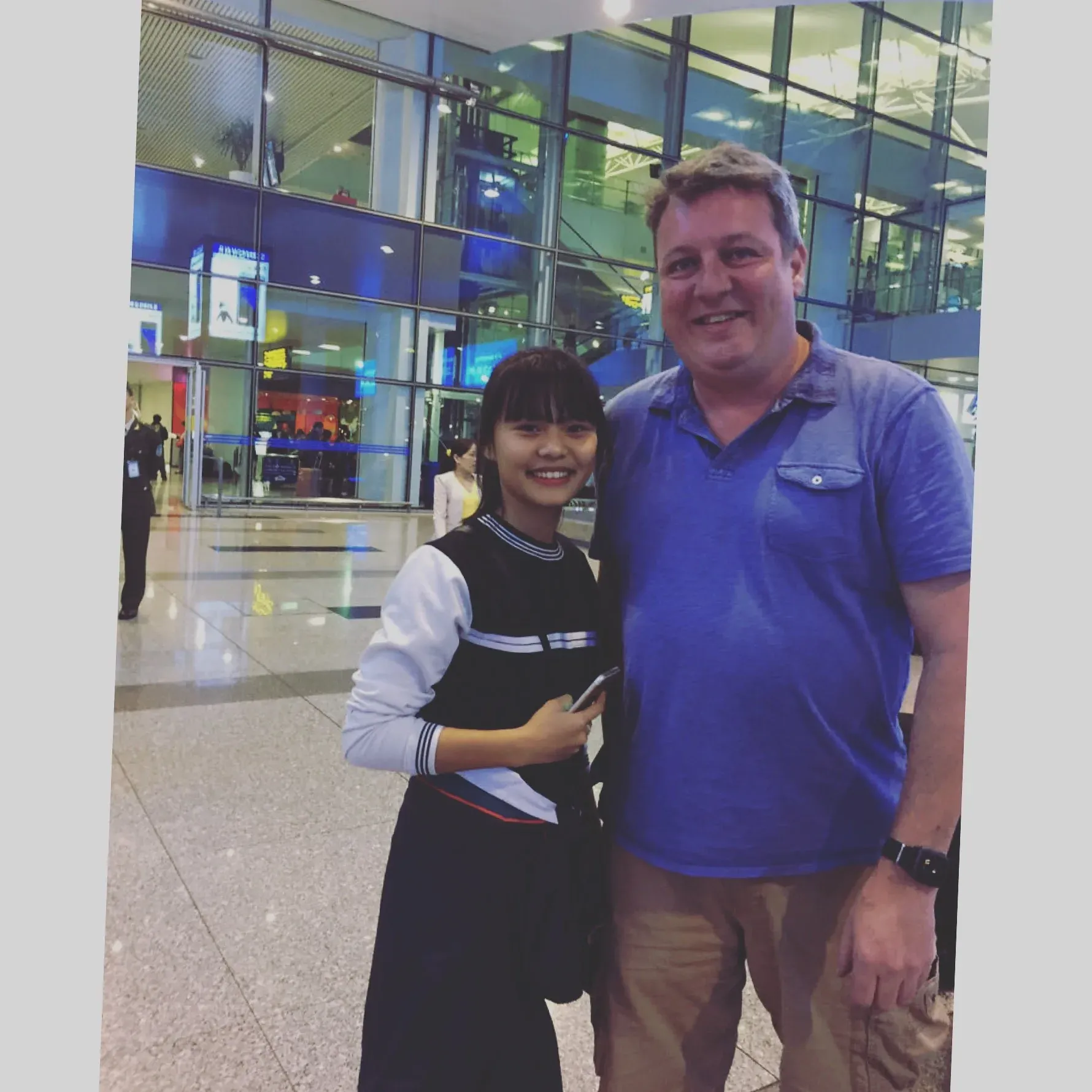 Man and young woman posing in modern airport terminal