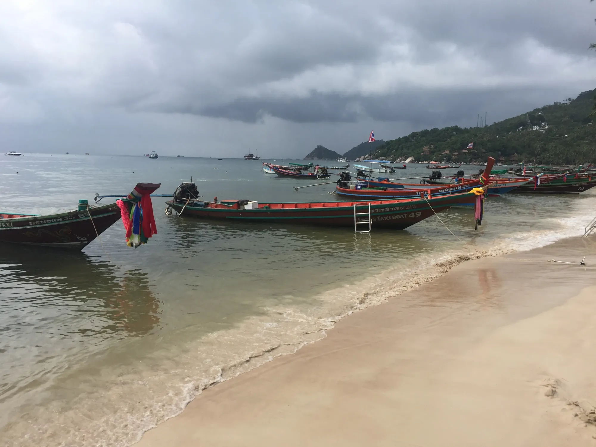 Colorful long-tail boats anchored off Thai beach