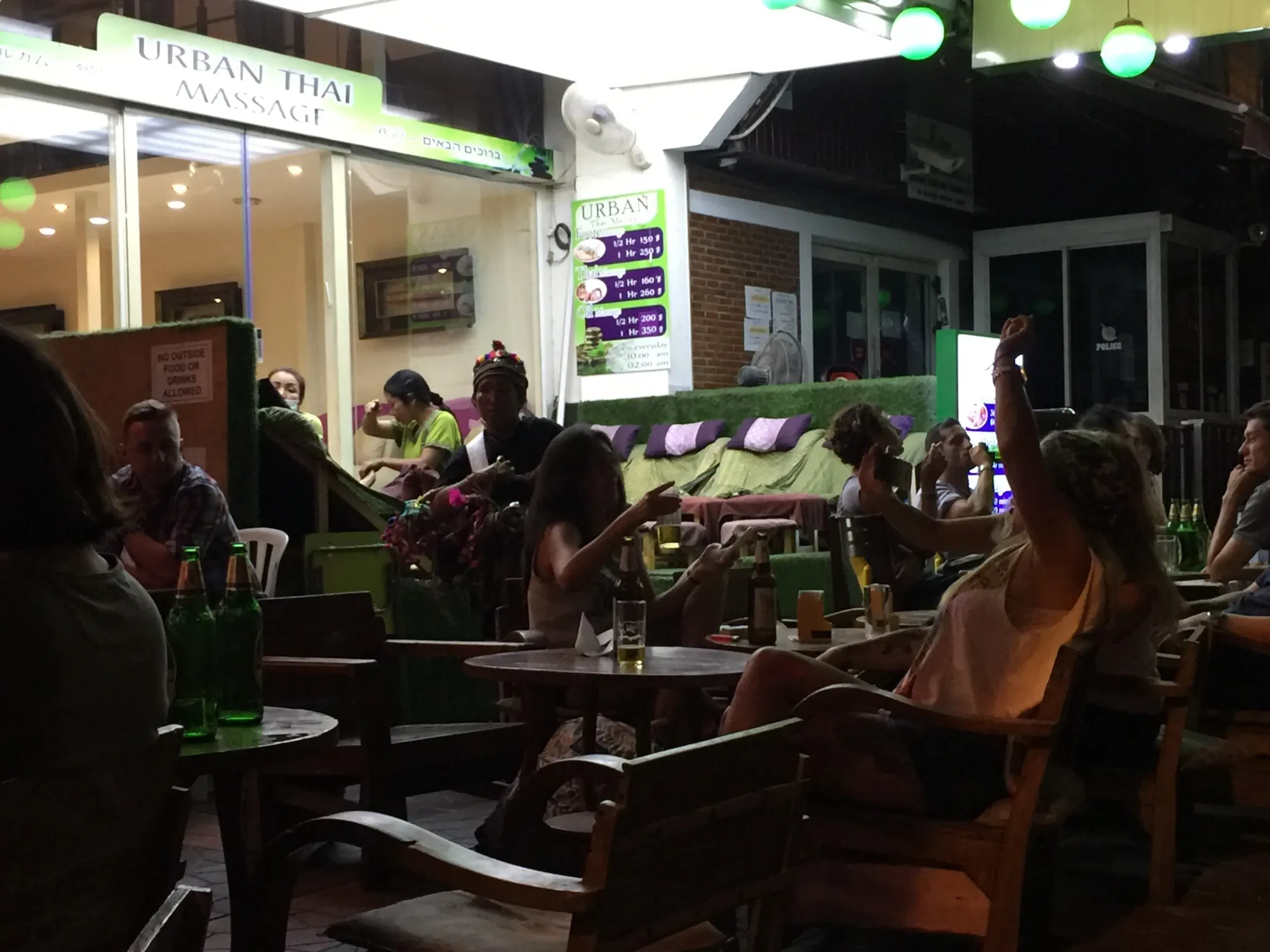 Busy outdoor bar with green lighting at night