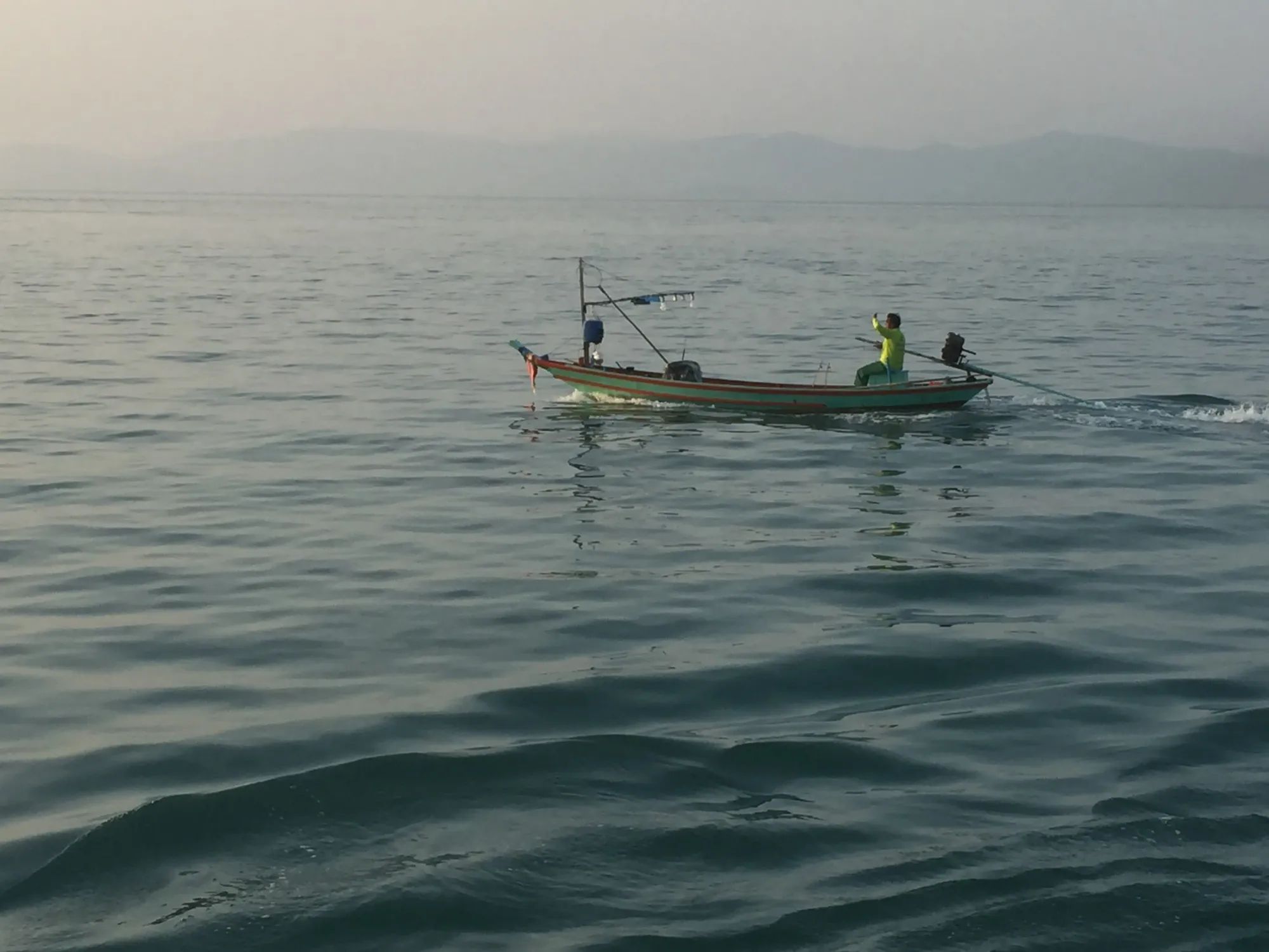 Fishing boat with crew in calm coastal waters