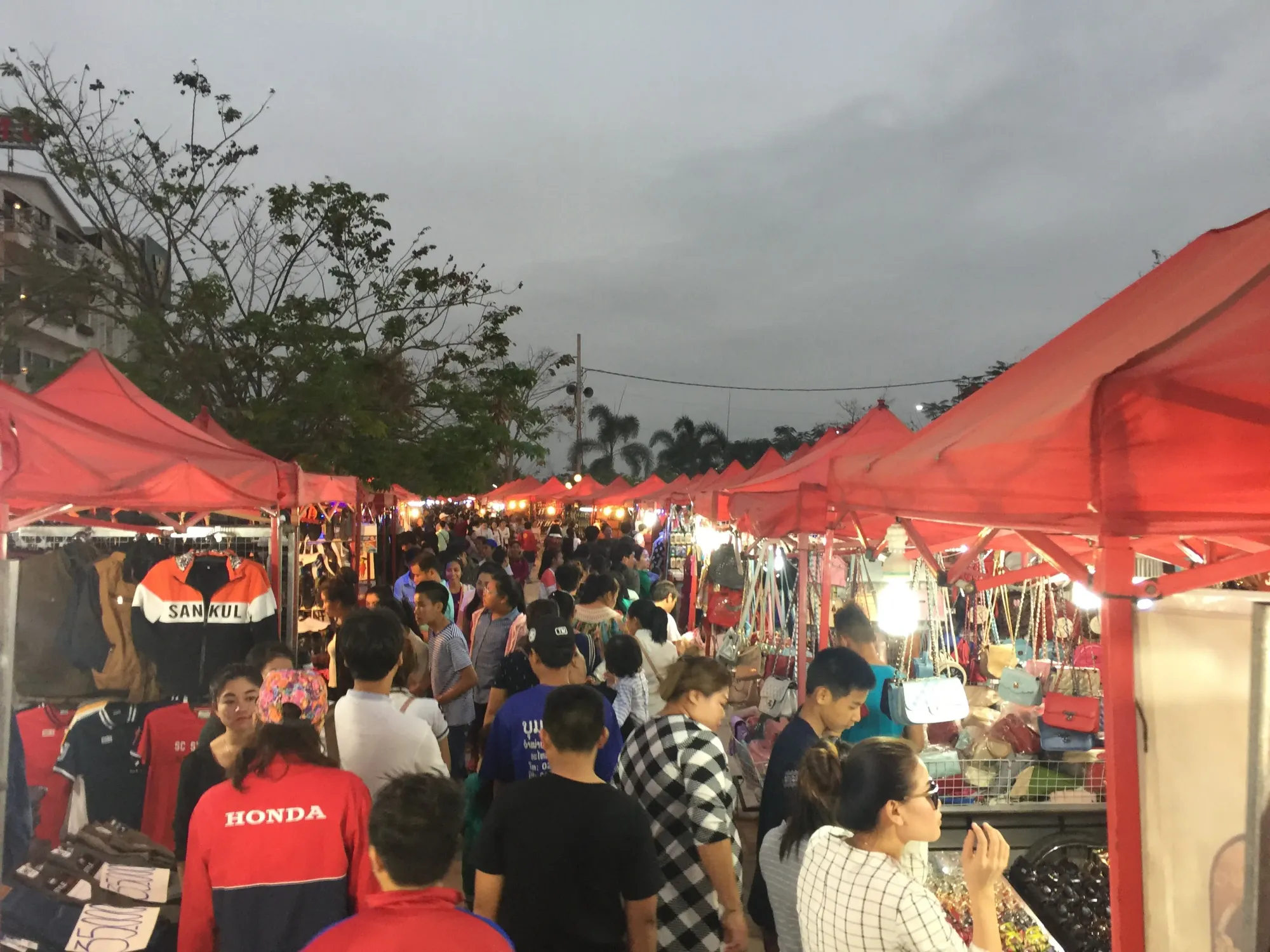 Crowded night market under red tents