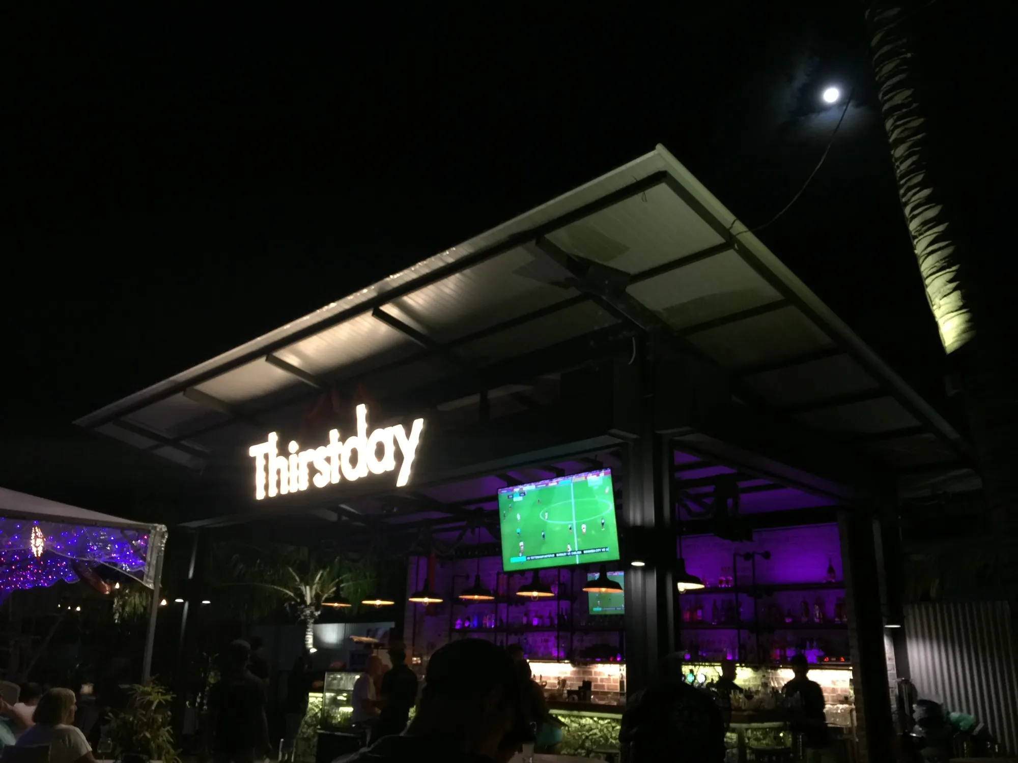 Thursday bar at night with soccer match on screen