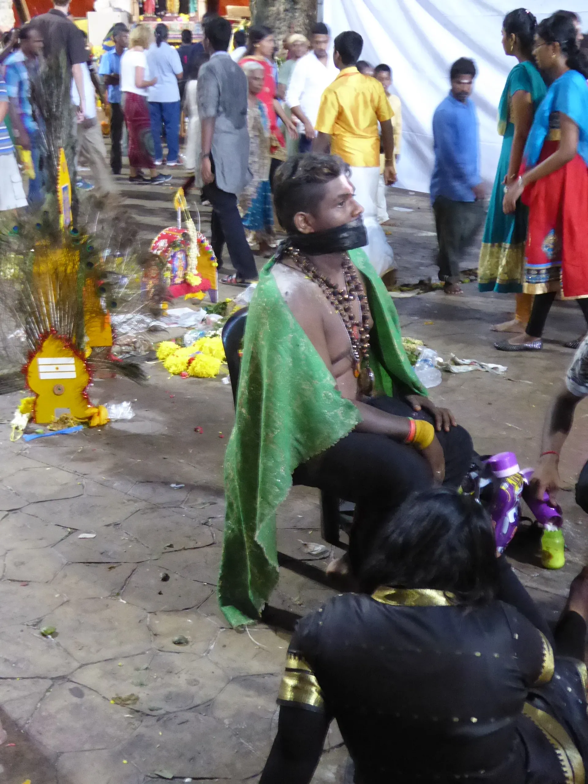 Man in green cloth at temple festival gathering