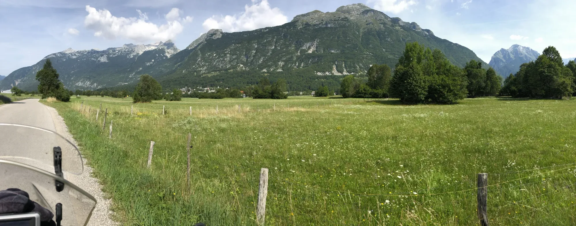 The KTM north of Bovec, Julian Alps behind, meadow in front — metres from the Street View spot.