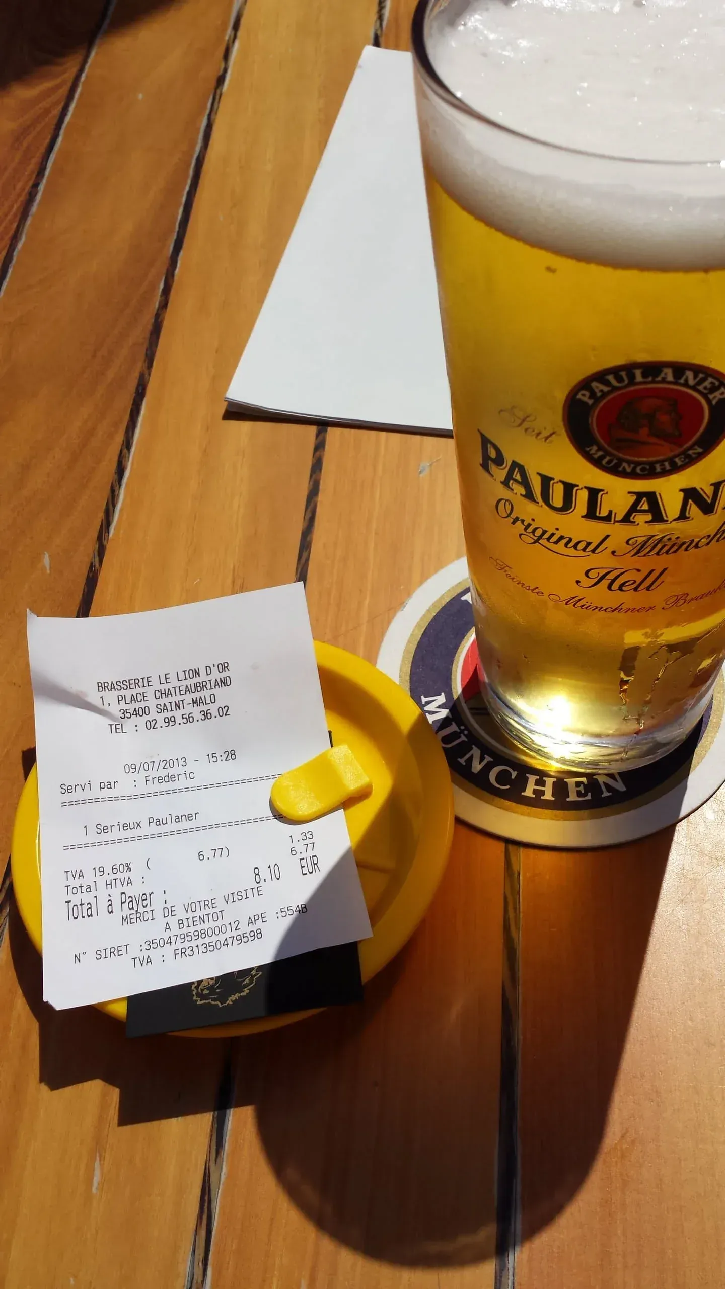 Paulaner beer and receipt at French café