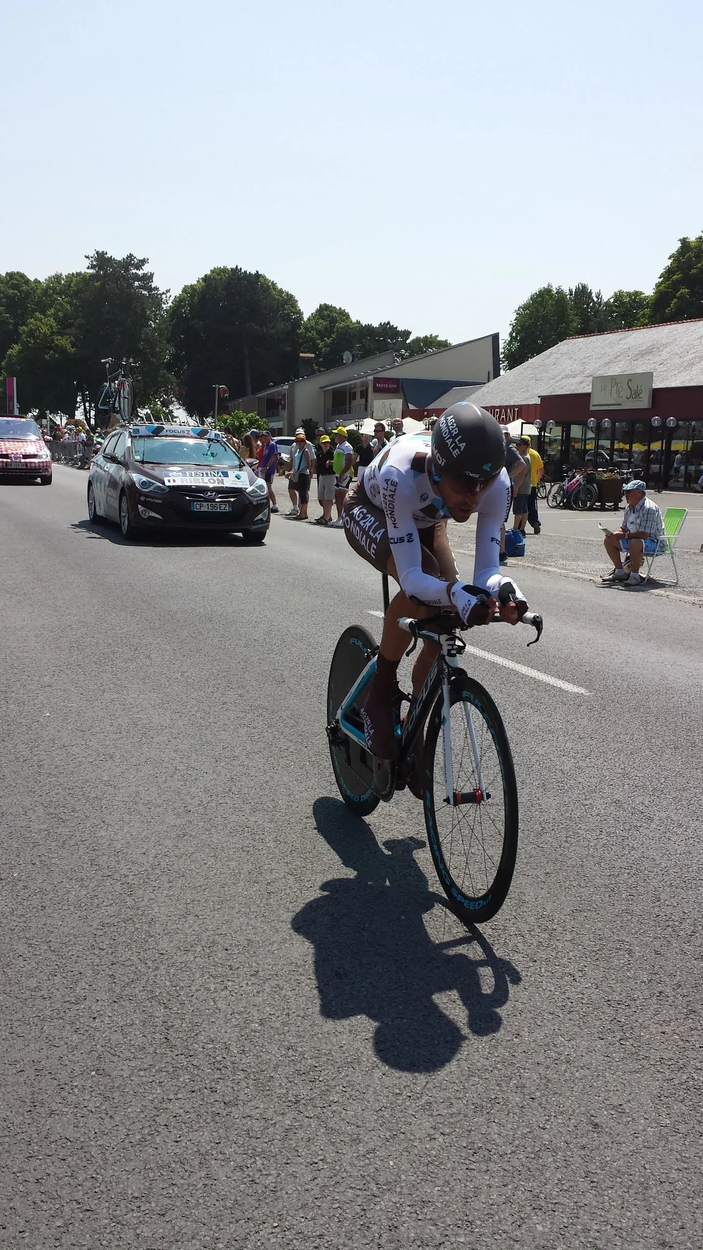Cyclist racing past support vehicle at Tour de France