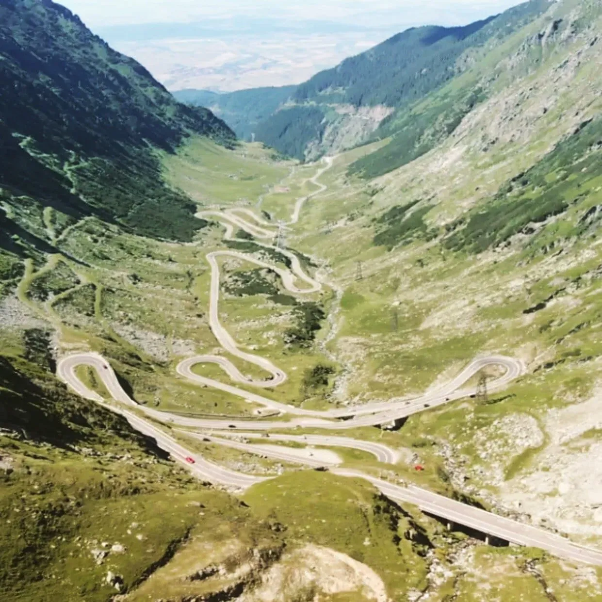 Winding mountain pass road with hairpin turns through Alpine valley