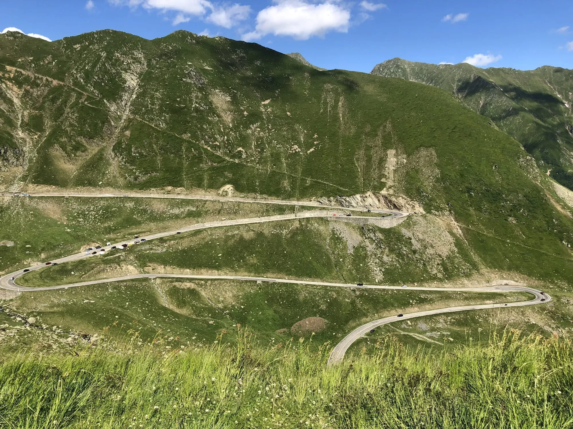 Winding mountain road with hairpin turns through Alpine valleys