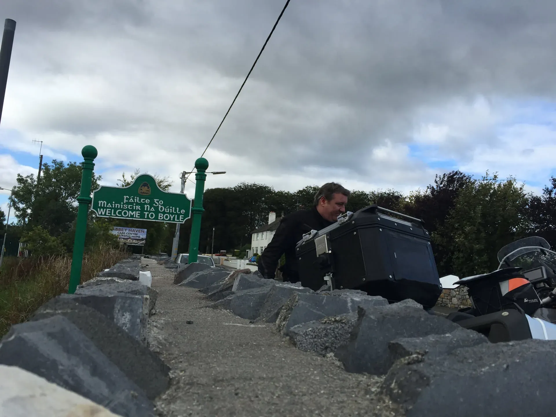 Man with motorcycle at Boyle welcome sign