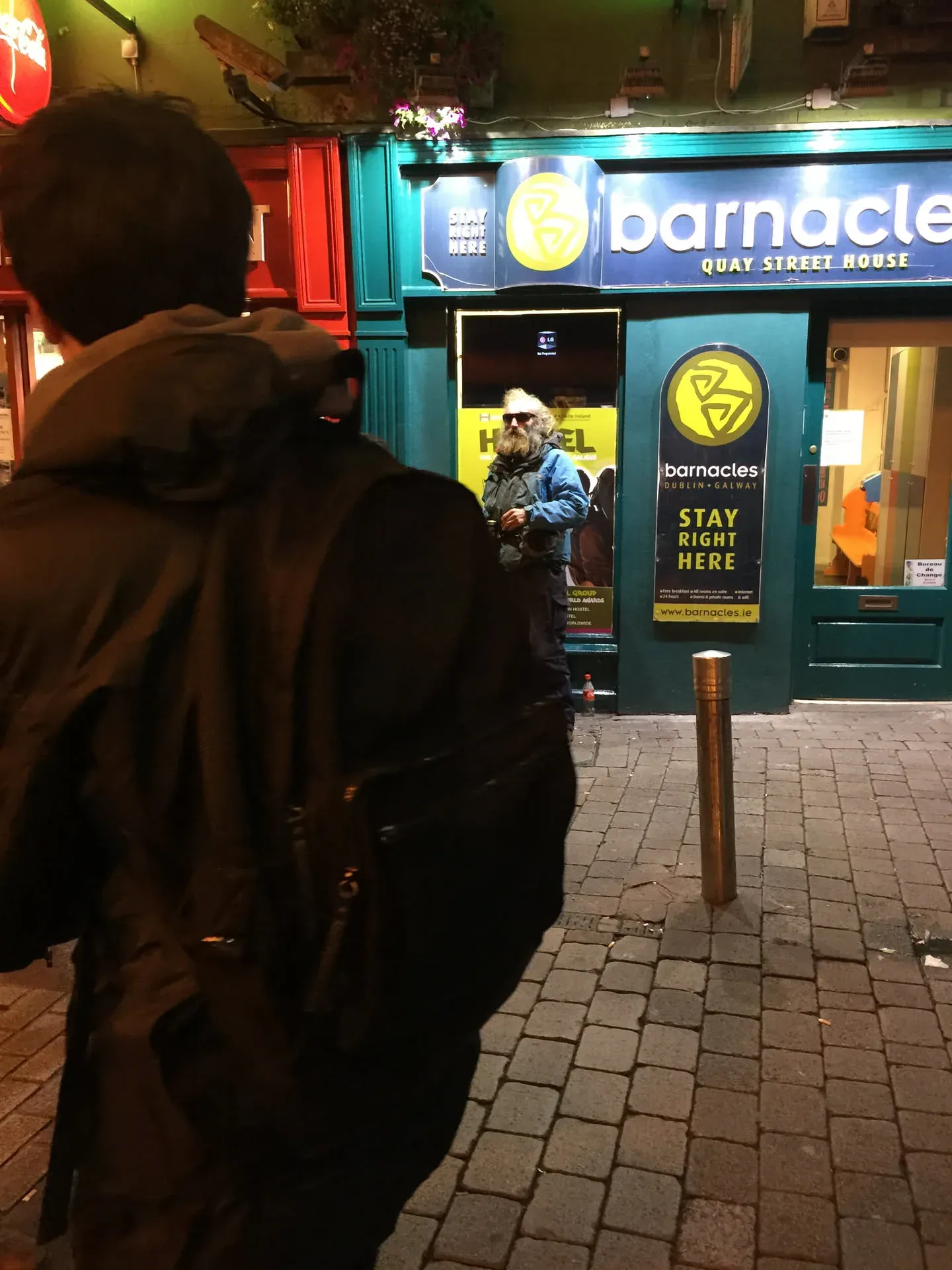 Person outside Barnacles hostel, Eyre Square, Galway