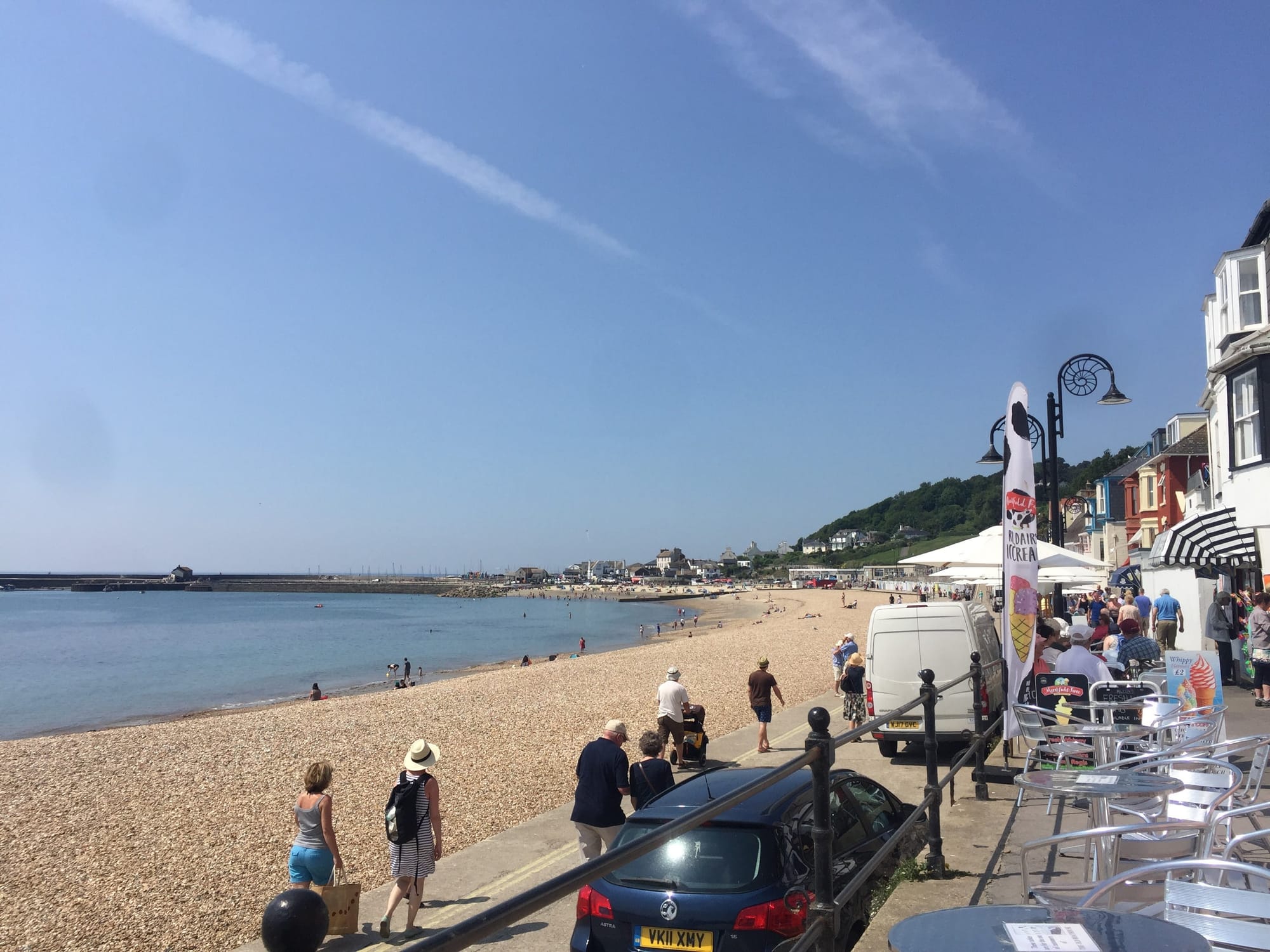 Busy beach day at Lyme Regis with seafront cafes